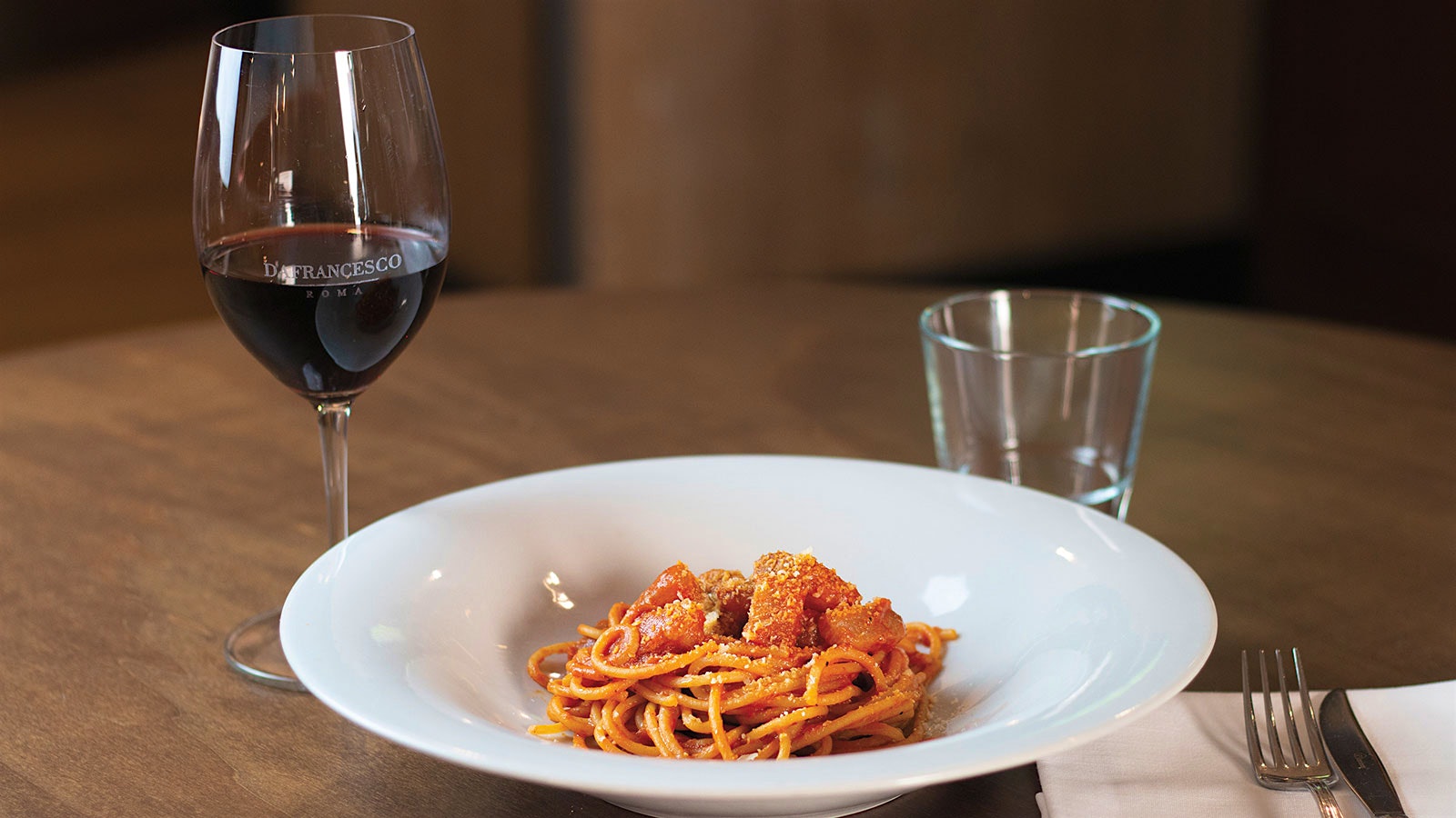  A plate of Spaghettoni all’amatriciana with a glass of red wine